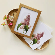 Framed botanical print with pink flowers on a wooden plate